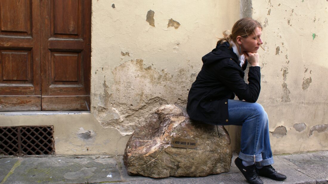 Kamień Dantego we Florencji. Dziewczyna siedzi na kamieniu