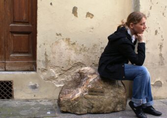 Kamień Dantego we Florencji. Dziewczyna siedzi na kamieniu